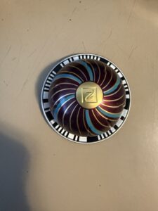 a nespresso pod with gold blue and a plummy brown